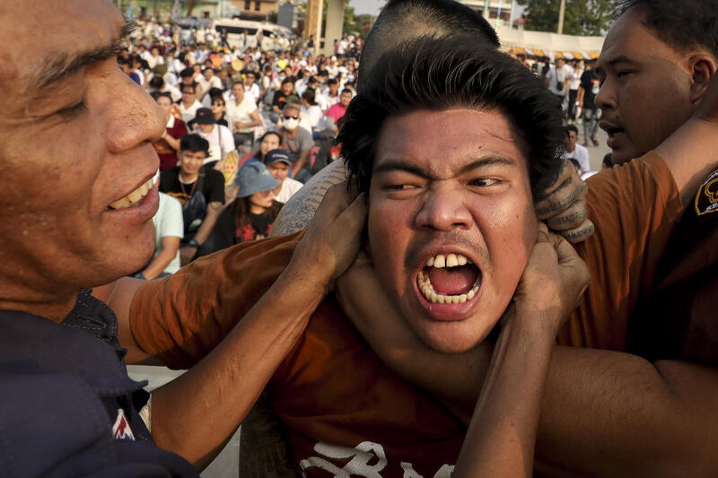 A devotee in a trance, believed to be possessed by the spirits of the animal tattooed on his skin, during the annual Magic Tattoo Festival at Wat Bang Phra in Nakhon Pathom province, Thailand, 23 March 2024. The Magic Tattoo Festival, also known as the 'Wai Khru Ceremony' (Wai Khru means 'honour the teacher'), attracts devotees from across the country who travel to Wat Bang Phra monastery to receive their traditional tattoos and pay their respects to the temple's master tattooist during the Magic Tattoo Festival. During the festival, devotees sit facing the main shrine before many, 'possessed' by the spirit of the animal tattooed on their skin, stand up, mimic the animal's behaviour and eventually make their way towards the main shrine, sometimes running at high speed, until they are stopped by a group of helpers and medics who bring them out of the trance by rubbing their ears. Receiving a Sak Yant is highly respected in Thailand, and many believe the tattoos have mystical powers to ward off bad luck and protect people from harm. Matrix Images / Diego Azubel