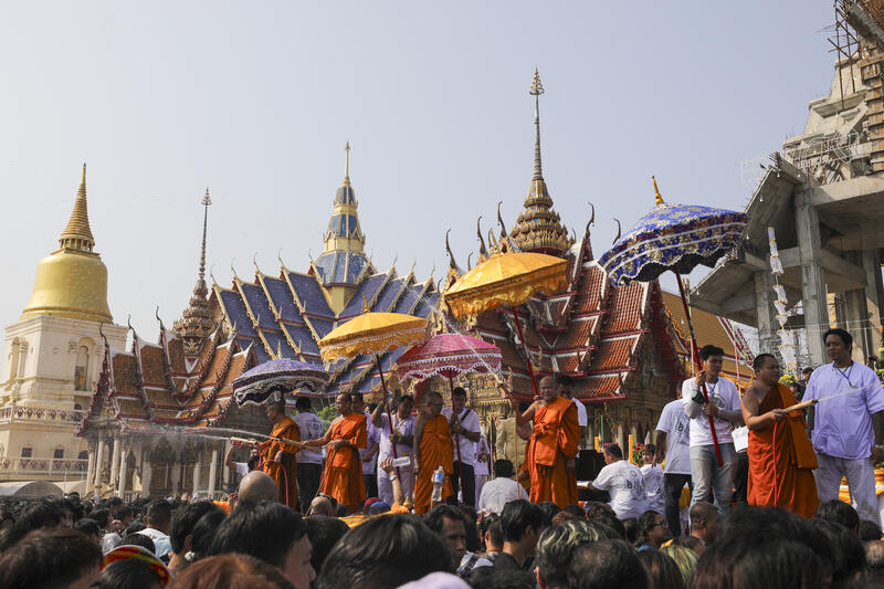 Devotees crowd under a stage waiting to receive holly water from a Thai Buddhist monk at the end of the annual Magic Tattoo Festival at Wat Bang Phra in Nakhon Pathom province, Thailand, 23 March 2024. The Magic Tattoo Festival, also known as the 'Wai Khru Ceremony' (Wai Khru means 'honour the teacher'), attracts devotees from across the country who travel to Wat Bang Phra monastery to receive their traditional tattoos and pay their respects to the temple's master tattooist during the Magic Tattoo Festival. During the festival, devotees sit facing the main shrine before many, 'possessed' by the spirit of the animal tattooed on their skin, stand up, mimic the animal's behaviour and eventually make their way towards the main shrine, sometimes running at high speed, until they are stopped by a group of helpers and medics who bring them out of the trance by rubbing their ears. Receiving a Sak Yant is highly respected in Thailand, and many believe the tattoos have mystical powers to ward off bad luck and protect people from harm. Matrix Images / Diego Azubel