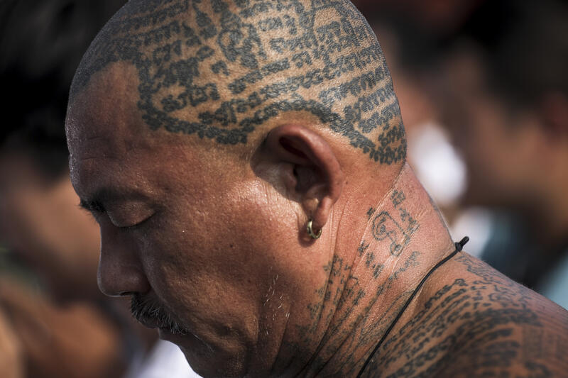 A devotee with his body covered in San Yant tattoo attends the annual Magic Tattoo Festival at Wat Bang Phra in Nakhon Pathom province, Thailand, 23 March 2024. The Magic Tattoo Festival, also known as the 'Wai Khru Ceremony' (Wai Khru means 'honour the teacher'), attracts devotees from across the country who travel to Wat Bang Phra monastery to receive their traditional tattoos and pay their respects to the temple's master tattooist during the Magic Tattoo Festival. During the festival, devotees sit facing the main shrine before many, 'possessed' by the spirit of the animal tattooed on their skin, stand up, mimic the animal's behaviour and eventually make their way towards the main shrine, sometimes running at high speed, until they are stopped by a group of helpers and medics who bring them out of the trance by rubbing their ears. Receiving a Sak Yant is highly respected in Thailand, and many believe the tattoos have mystical powers to ward off bad luck and protect people from harm. Matrix Images / Diego Azubel