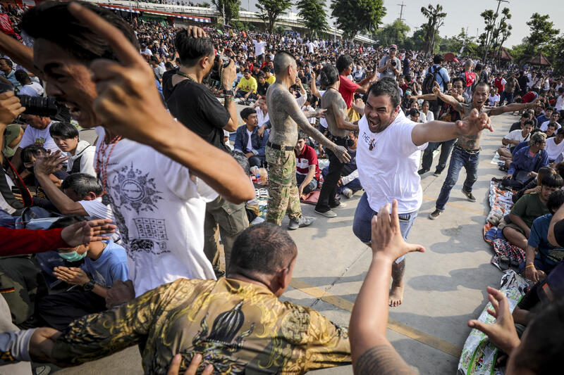 A devotee in a trance, believed to be possessed by the spirits of the animal tattooed on his skin, during the annual Magic Tattoo Festival at Wat Bang Phra in Nakhon Pathom province, Thailand, 23 March 2024. The Magic Tattoo Festival, also known as the 'Wai Khru Ceremony' (Wai Khru means 'honour the teacher'), attracts devotees from across the country who travel to Wat Bang Phra monastery to receive their traditional tattoos and pay their respects to the temple's master tattooist during the Magic Tattoo Festival. During the festival, devotees sit facing the main shrine before many, 'possessed' by the spirit of the animal tattooed on their skin, stand up, mimic the animal's behaviour and eventually make their way towards the main shrine, sometimes running at high speed, until they are stopped by a group of helpers and medics who bring them out of the trance by rubbing their ears. Receiving a Sak Yant is highly respected in Thailand, and many believe the tattoos have mystical powers to ward off bad luck and protect people from harm. Matrix Images / Diego Azubel