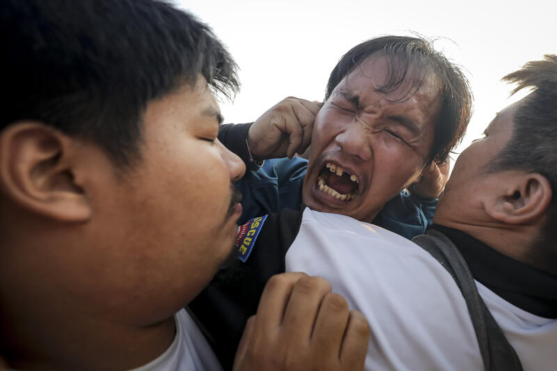 A devotee in a trance, believed to be possessed by the spirits of the animal tattooed on his skin, during the annual Magic Tattoo Festival at Wat Bang Phra in Nakhon Pathom province, Thailand, 23 March 2024. The Magic Tattoo Festival, also known as the 'Wai Khru Ceremony' (Wai Khru means 'honour the teacher'), attracts devotees from across the country who travel to Wat Bang Phra monastery to receive their traditional tattoos and pay their respects to the temple's master tattooist during the Magic Tattoo Festival. During the festival, devotees sit facing the main shrine before many, 'possessed' by the spirit of the animal tattooed on their skin, stand up, mimic the animal's behaviour and eventually make their way towards the main shrine, sometimes running at high speed, until they are stopped by a group of helpers and medics who bring them out of the trance by rubbing their ears. Receiving a Sak Yant is highly respected in Thailand, and many believe the tattoos have mystical powers to ward off bad luck and protect people from harm. Matrix Images / Diego Azubel