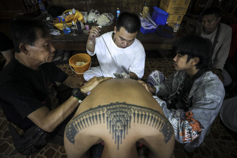 A devotee gets a San Yant tattoo by a tattoo master during the annual Magic Tattoo Festival at Wat Bang Phra in Nakhon Pathom province, Thailand, 23 March 2024. The Magic Tattoo Festival, also known as the 'Wai Khru Ceremony' (Wai Khru means 'honour the teacher'), attracts devotees from across the country who travel to Wat Bang Phra monastery to receive their traditional tattoos and pay their respects to the temple's master tattooist during the Magic Tattoo Festival. During the festival, devotees sit facing the main shrine before many, 'possessed' by the spirit of the animal tattooed on their skin, stand up, mimic the animal's behaviour and eventually make their way towards the main shrine, sometimes running at high speed, until they are stopped by a group of helpers and medics who bring them out of the trance by rubbing their ears. Receiving a Sak Yant is highly respected in Thailand, and many believe the tattoos have mystical powers to ward off bad luck and protect people from harm. Matrix Images / Diego Azubel