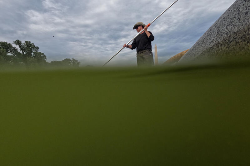 Workers remove algae from the Lincoln Memorial Reflecting Pool in Washington DC, USA.