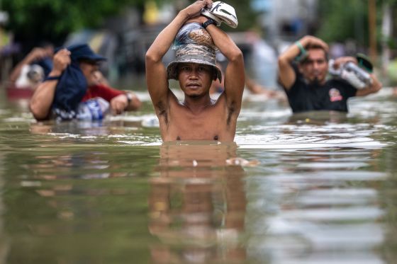 people wading through flooded street